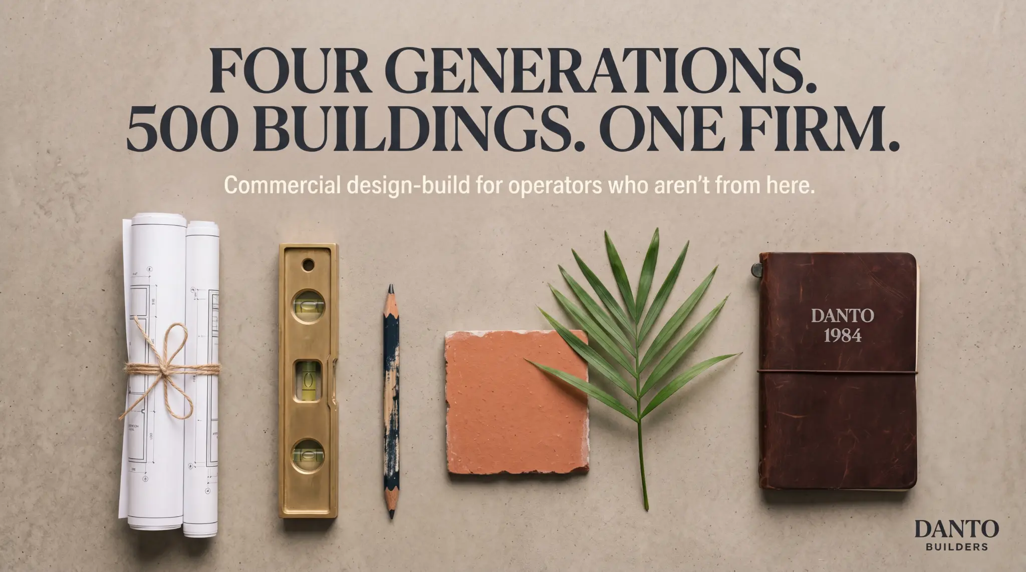 Flat lay of builder tools — level, pencil, tile, palm leaf, Danto 1984 journal